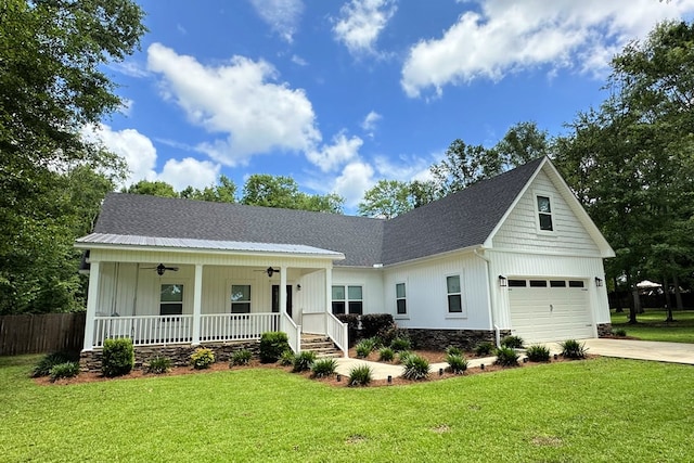 view of front of home with ceiling fan, covered porch, a front yard, and a garage