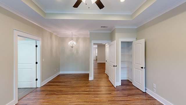 unfurnished room featuring crown molding, wood-type flooring, and ceiling fan with notable chandelier