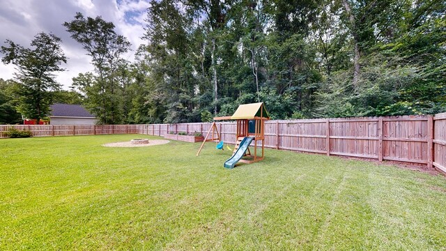 view of yard with a playground and an outdoor fire pit