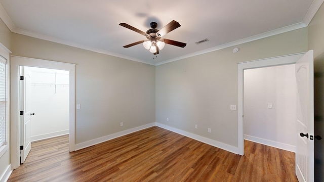 unfurnished room with wood-type flooring, ceiling fan, and crown molding