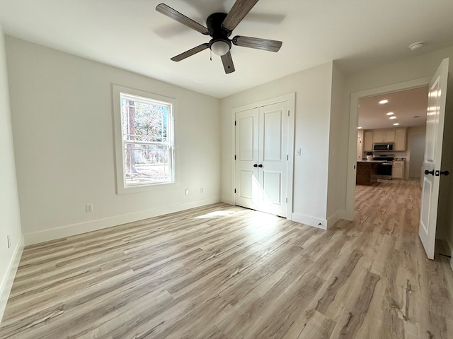 unfurnished bedroom with light wood-type flooring, a closet, and ceiling fan