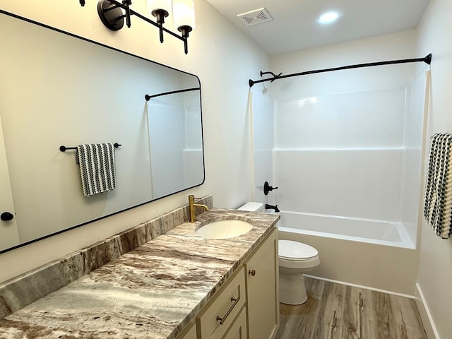 full bathroom with hardwood / wood-style floors, vanity, shower / bath combination, and toilet