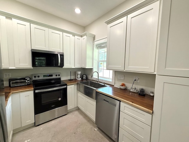 245 County Road 422, Abbeville, AL 36310 - kitchen with appliances with stainless steel finishes, wood counters, concrete flooring, white cabinetry, and recessed lighting