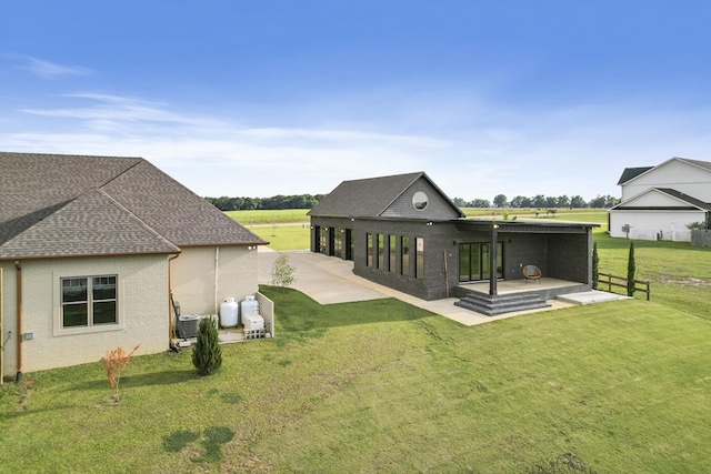 481 Grace Dr, Newton, AL 36352 - back of house featuring brick siding, a yard, a patio, a shingled roof, and central AC unit