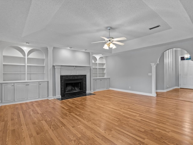 3602 Lake Oak Ridge Dr, Enterprise, AL 36330 - unfurnished living room featuring a textured ceiling, a ceiling fan, built in features, arched walkways, and light wood-style floors