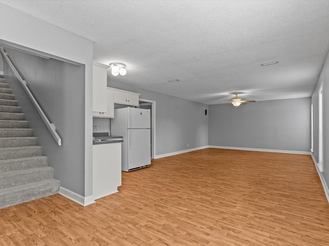 3602 Lake Oak Ridge Dr, Enterprise, AL 36330 - kitchen with freestanding refrigerator, light wood-type flooring, open floor plan, a textured ceiling, and a ceiling fan