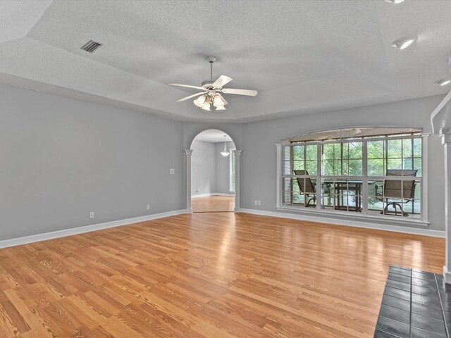 3602 Lake Oak Ridge Dr, Enterprise, AL 36330 - spare room featuring a textured ceiling, light wood finished floors, arched walkways, ceiling fan, and baseboards
