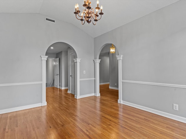 3602 Lake Oak Ridge Dr, Enterprise, AL 36330 - unfurnished room featuring a chandelier, lofted ceiling, arched walkways, wood finished floors, and baseboards