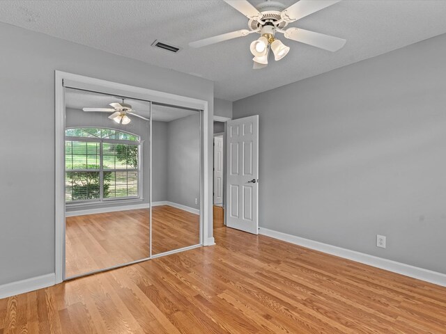3602 Lake Oak Ridge Dr, Enterprise, AL 36330 - unfurnished bedroom featuring wood finished floors, a closet, baseboards, ceiling fan, and a textured ceiling