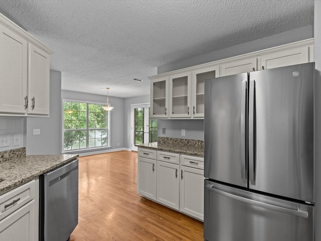 3602 Lake Oak Ridge Dr, Enterprise, AL 36330 - kitchen featuring appliances with stainless steel finishes, white cabinetry, glass insert cabinets, and a textured ceiling