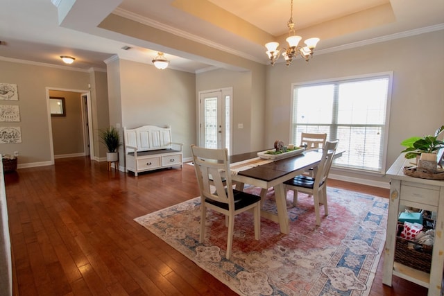 dining room featuring crown molding, a notable chandelier, a tray ceiling, and hardwood / wood-style flooring