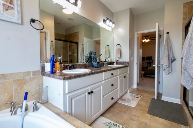 bathroom with connected bathroom, double vanity, a sink, and a stall shower