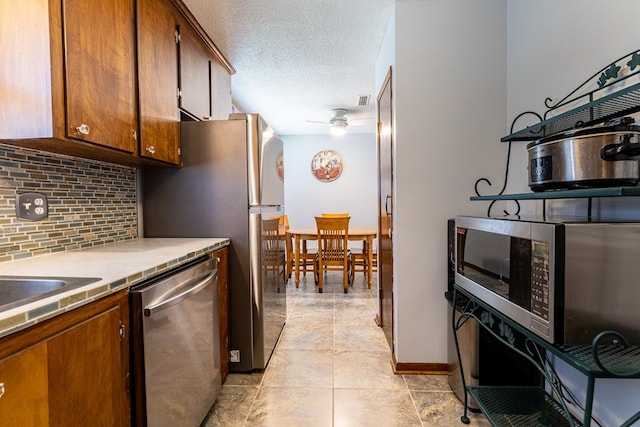 847 Phyllis Ave, Enterprise, AL 36330 - kitchen featuring stainless steel appliances, decorative backsplash, ceiling fan, light countertops, and brown cabinetry