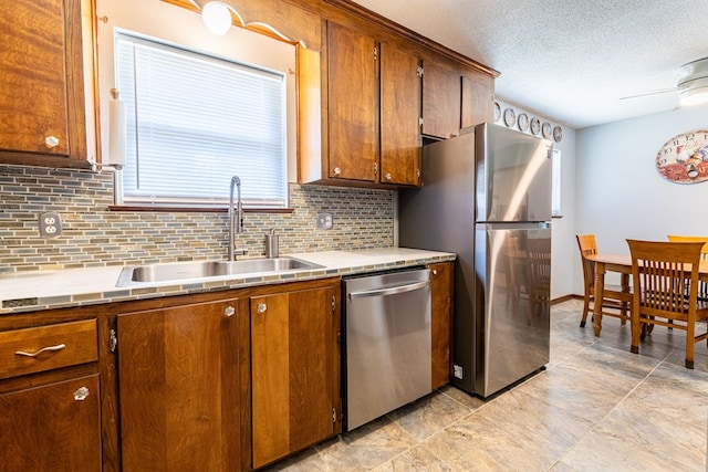 847 Phyllis Ave, Enterprise, AL 36330 - kitchen featuring appliances with stainless steel finishes, a sink, tasteful backsplash, a textured ceiling, and light countertops