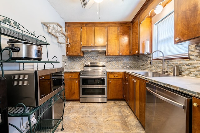 847 Phyllis Ave, Enterprise, AL 36330 - kitchen with stainless steel appliances, a sink, brown cabinets, tasteful backsplash, and light countertops