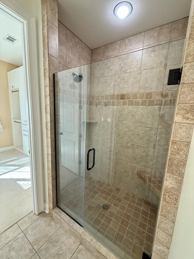 bathroom with tile patterned floors and a shower with door