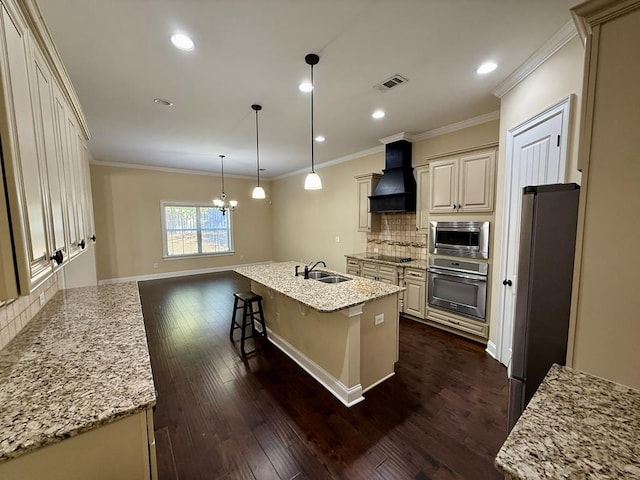 kitchen with sink, hanging light fixtures, stainless steel appliances, an island with sink, and custom exhaust hood