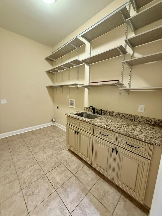 laundry area featuring sink, cabinets, light tile patterned floors, hookup for a washing machine, and electric dryer hookup