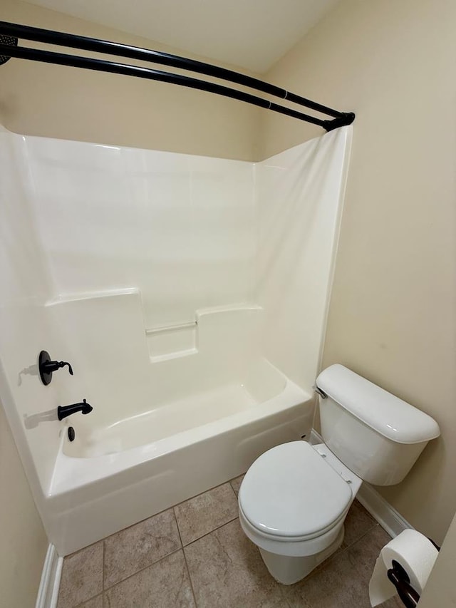 bathroom with tub / shower combination, tile patterned floors, and toilet