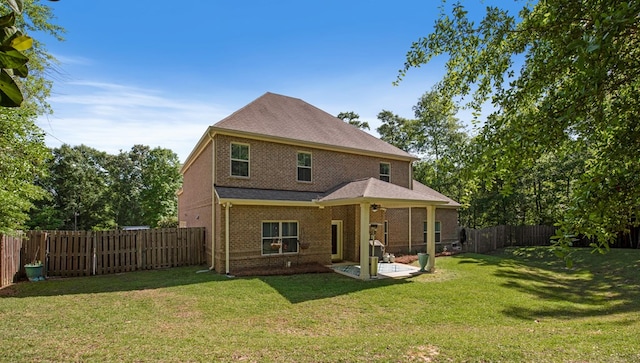 rear view of property featuring a yard and a patio area