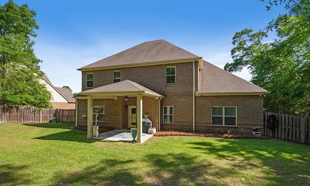 back of house with a patio and a lawn