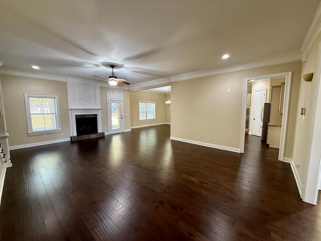 unfurnished living room with dark hardwood / wood-style flooring, ceiling fan, crown molding, and a healthy amount of sunlight