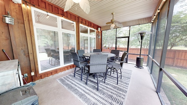 sunroom with outdoor dining area and a ceiling fan