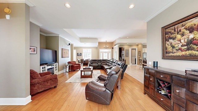 living room with an inviting chandelier, light wood-style flooring, baseboards, ornamental molding, and recessed lighting