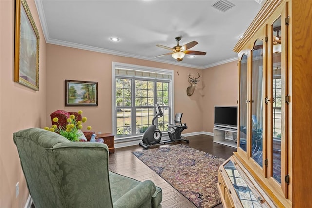 living room with dark wood-style floors, visible vents, crown molding, and ceiling fan