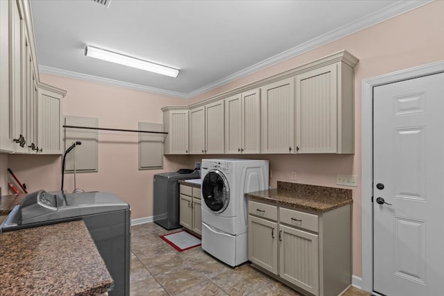 washroom featuring baseboards, cabinet space, independent washer and dryer, and crown molding