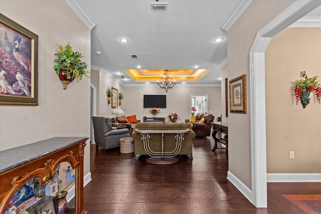 interior space with a tray ceiling, visible vents, and ornamental molding