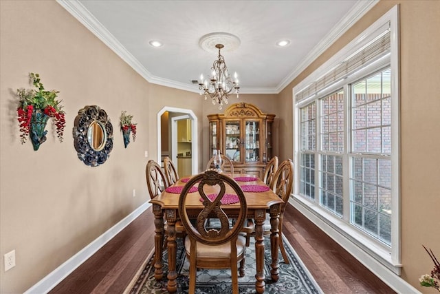 dining room featuring crown molding, baseboards, a chandelier, and dark wood finished floors