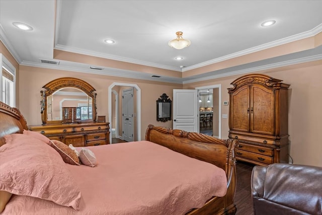 bedroom featuring visible vents, ornamental molding, wood finished floors, recessed lighting, and a raised ceiling