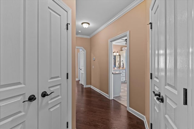 hall with baseboards, ornamental molding, and dark wood finished floors