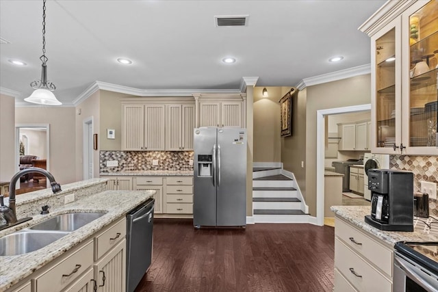 kitchen featuring a sink, pendant lighting, stainless steel appliances, visible vents, and cream cabinetry