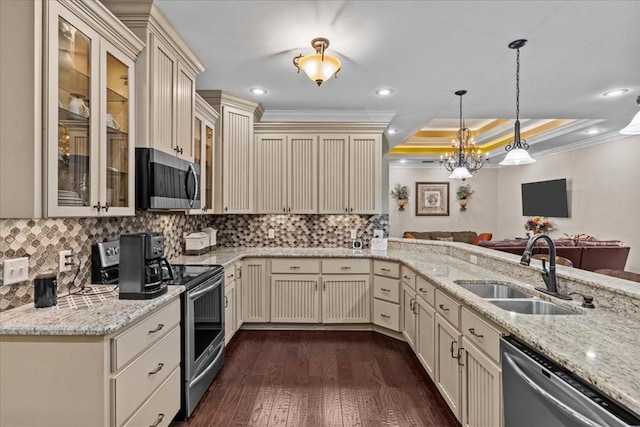 kitchen with a sink, cream cabinetry, appliances with stainless steel finishes, and dark wood-style floors