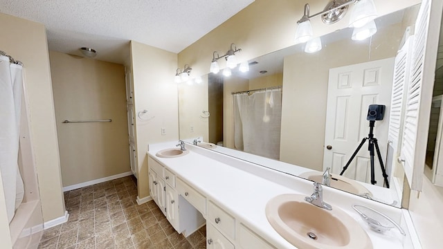 100 W Fontana Cir, Dothan, AL 36305 - bathroom featuring a shower with shower curtain, a sink, double vanity, and a textured ceiling