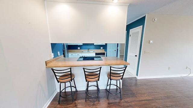 100 W Fontana Cir, Dothan, AL 36305 - kitchen featuring black electric cooktop, ornamental molding, a sink, dark wood-style flooring, and a breakfast bar area