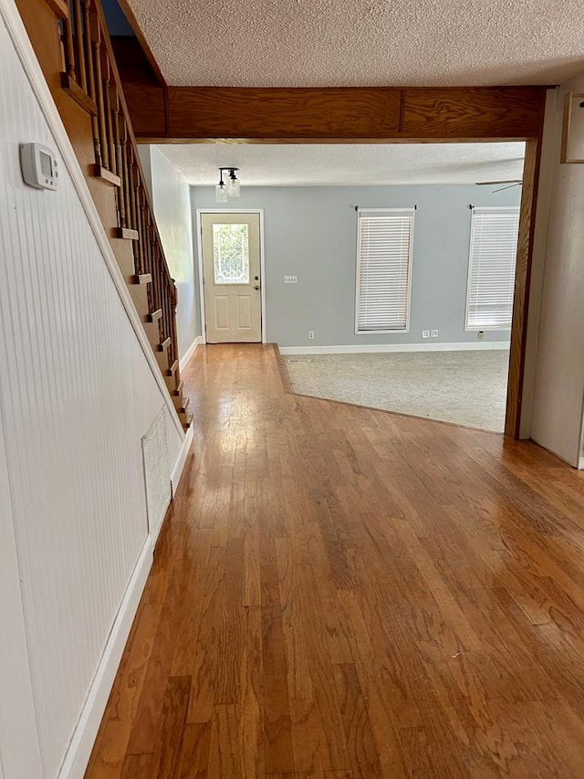 foyer with a textured ceiling and light hardwood / wood-style flooring