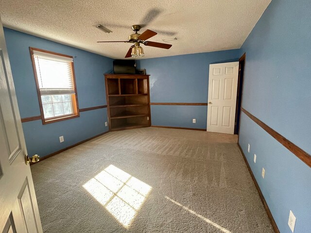 empty room with carpet, a textured ceiling, and ceiling fan