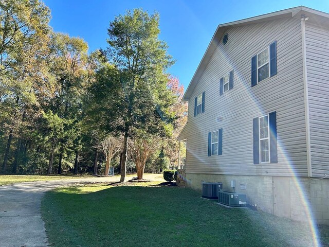 view of home's exterior featuring central air condition unit and a lawn