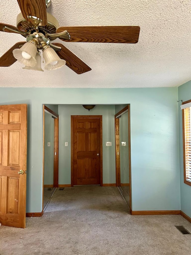 interior space with ceiling fan and a textured ceiling