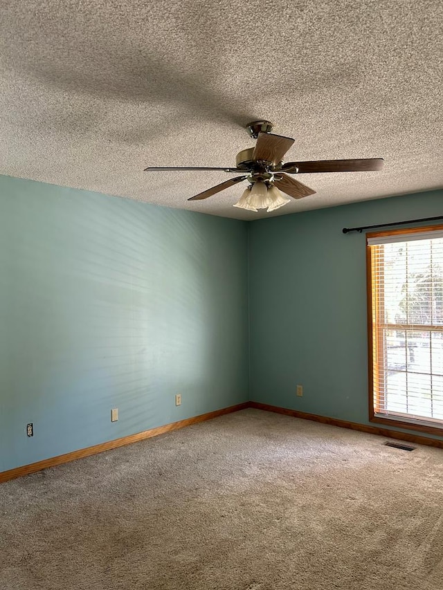 carpeted spare room with ceiling fan and a textured ceiling