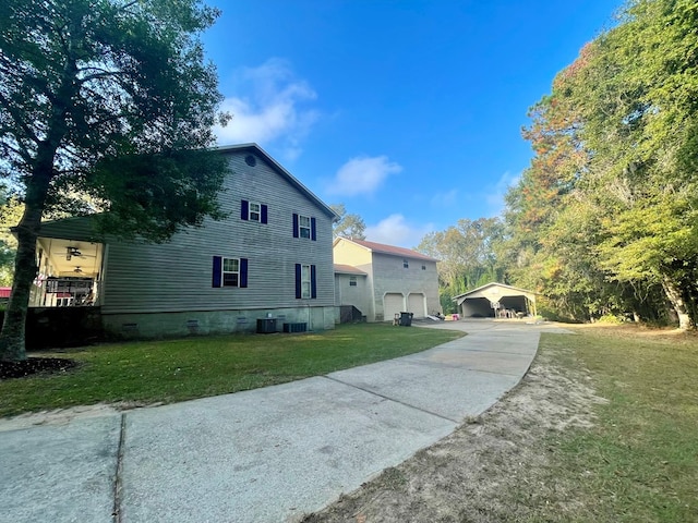 view of property exterior featuring a carport, a garage, a yard, and central AC