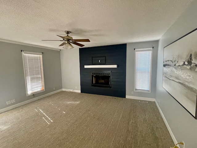 unfurnished living room with a fireplace, ceiling fan, wood-type flooring, and a textured ceiling