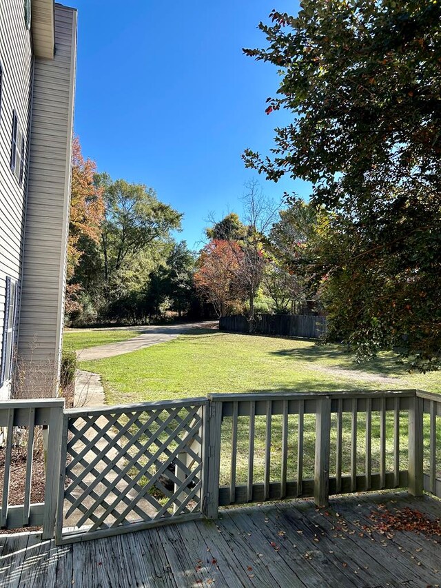 wooden deck featuring a lawn