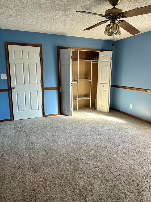 unfurnished bedroom with ceiling fan, a closet, carpet, and a textured ceiling