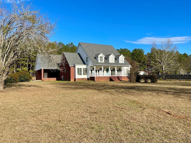 cape cod-style house with a porch, a front yard, and a garage