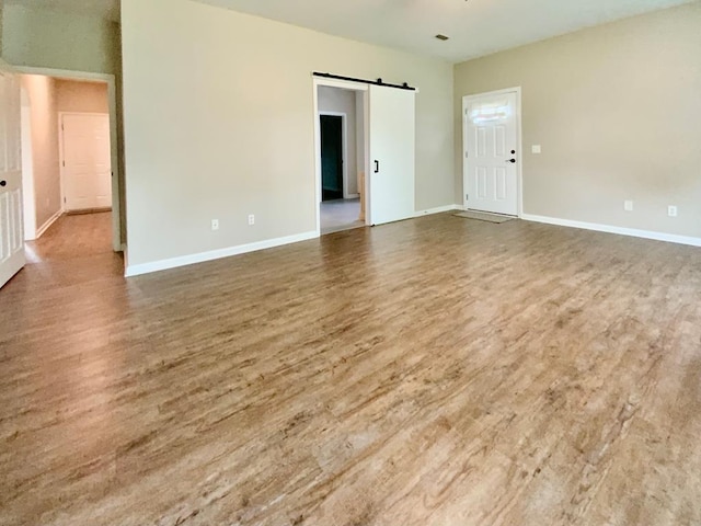 30 Cotton Creek Blvd, Enterprise, AL 36330 - spare room featuring a barn door and wood finished floors