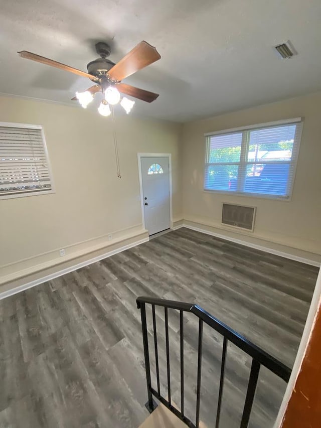 entrance foyer with ceiling fan, ornamental molding, and dark wood-type flooring